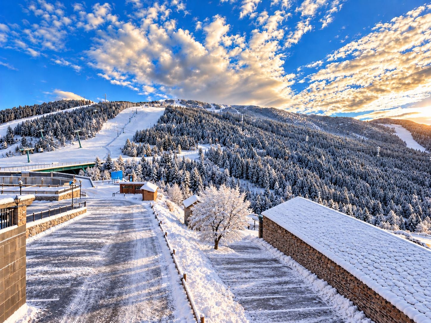 A snow-covered landscape with a ski resort, buildings, and a clear sky.
