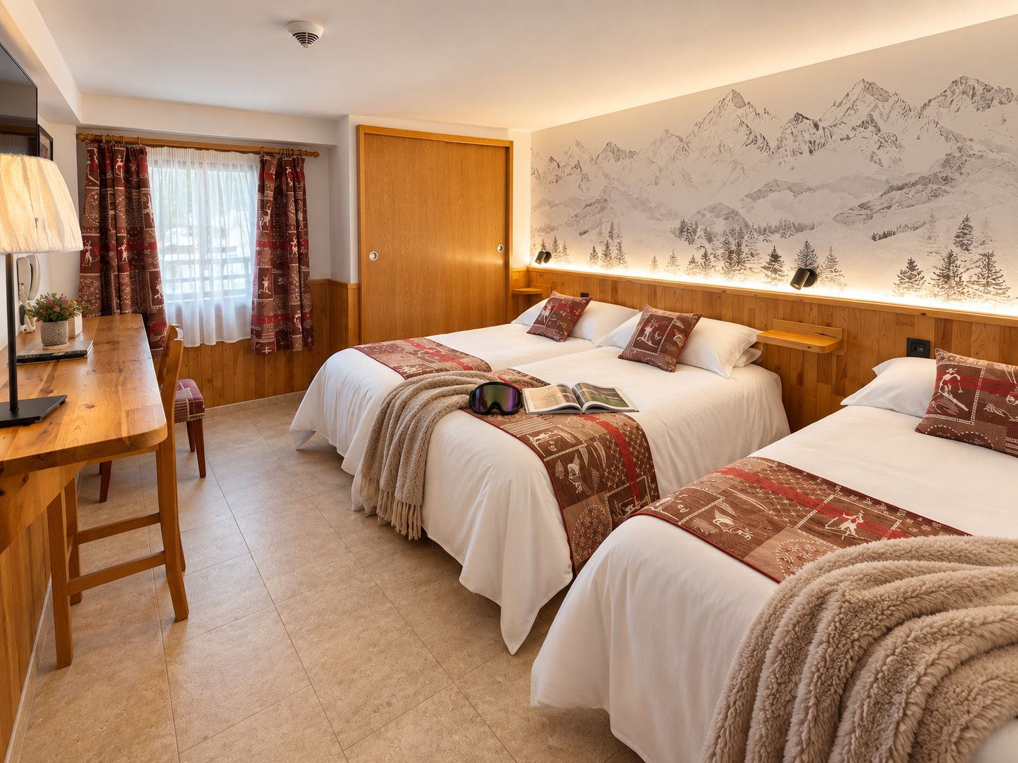 Quarto de hotel com duas camas, uma escrivaninha de madeira, uma luminária e uma parede com um mural de montanhas.