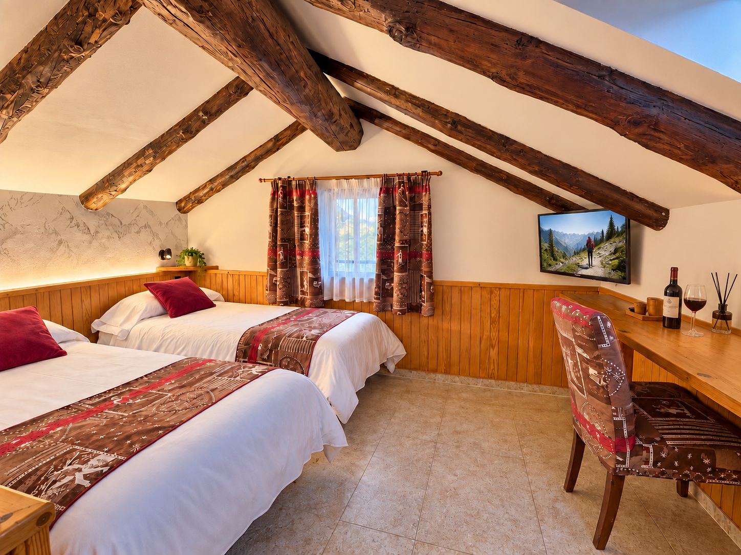 Una habitación acogedora con dos camas, vigas de madera, un escritorio y una ventana con cortinas estampadas.