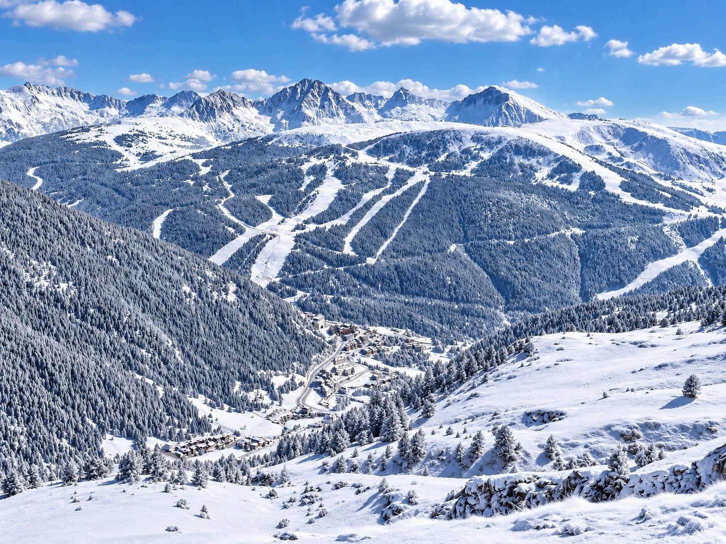 A snow-covered mountain landscape with ski trails and a small settlement.