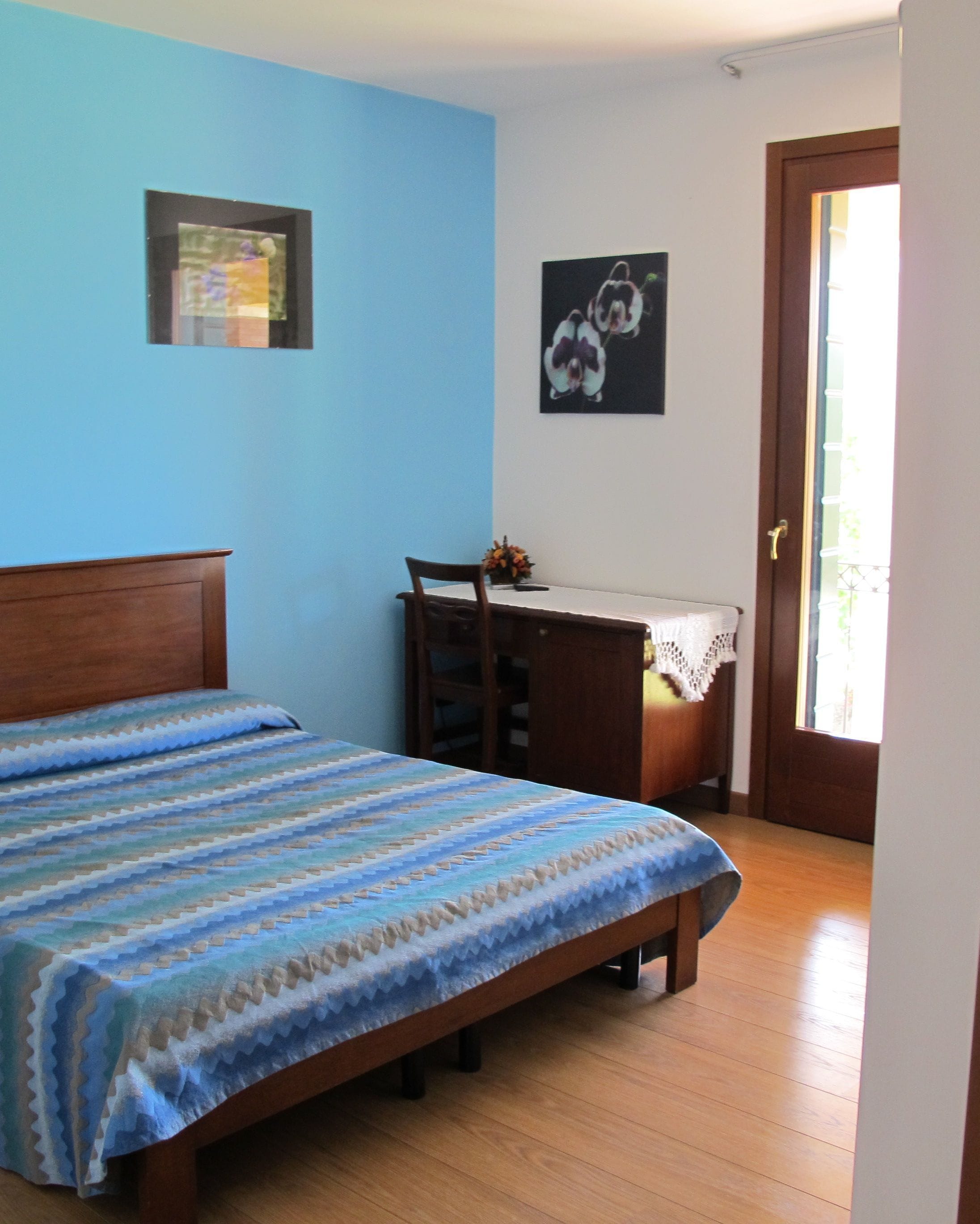 Un dormitorio con una cama, un escritorio y una silla.