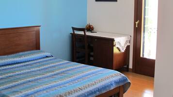 Un dormitorio con una cama, un escritorio y una silla.