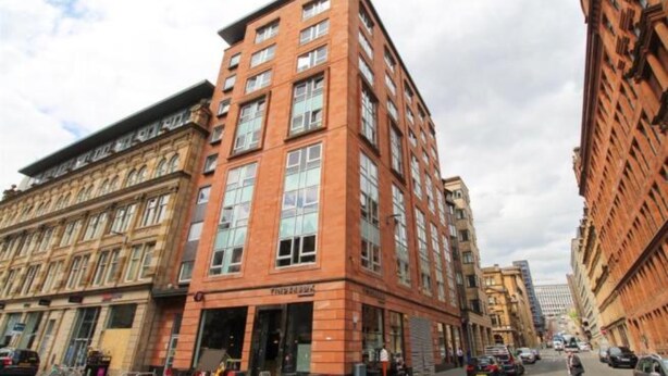 A multi-story building with a prominent corner entrance, large windows, and a brick facade. - Dreamhouse Apartments Glasgow City Centre (Glasgow)
