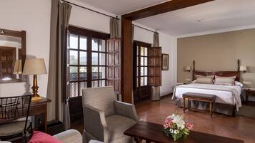 Una habitación de hotel con una cama, una silla, una mesa y un escritorio con una lámpara.