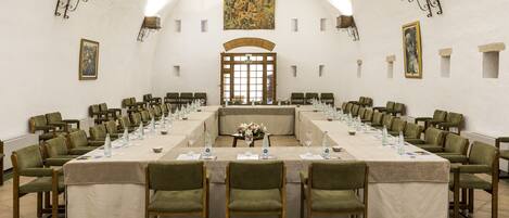 A conference room with a long table, chairs, and a large window.