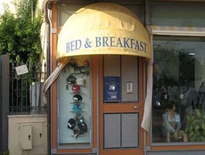 A storefront with a sign reading "BED & BREAKFAST" and a display of various hats inside. - Torre Clementina (Fiumicino)