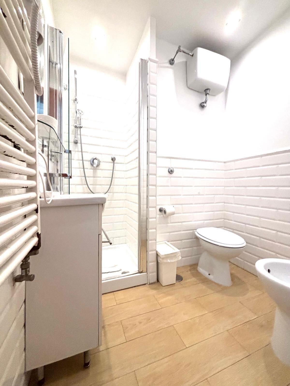 Un bagno con doccia, WC, bidet e lavandino.