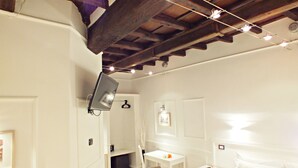 A bedroom with a wooden ceiling, a bed, a desk, and a chair. - Domus Ester Roma (Rome)