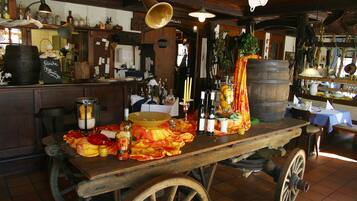A rustic bar area with a wooden table, bottles, and a large beer mug.