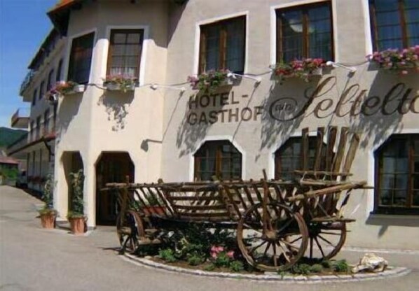 A building labeled "HOTEL-GASTHOF" with a traditional carriage in front.