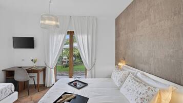Una camera da letto con un letto, una scrivania, una sedia, una TV e vista sull'esterno.