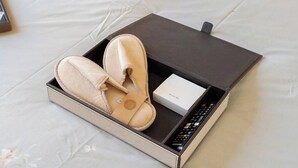 Slippers en een afstandsbediening in een doos.