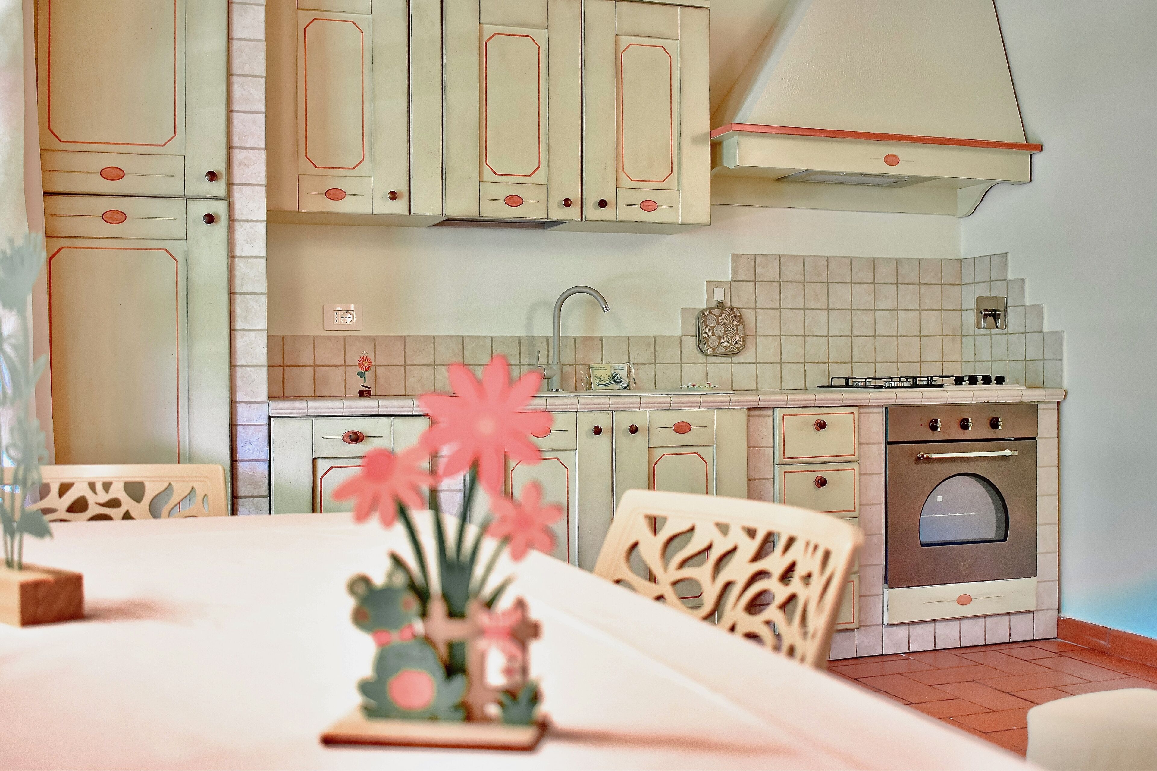 Una cucina con mobili chiari, un lavello e un forno.