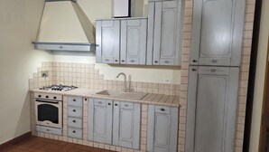 Una cocina compacta con estufa a gas, pileta y alacenas.