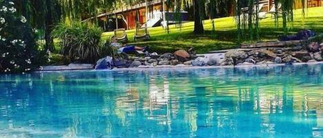 Una piscina al aire libre de temporada, tumbonas