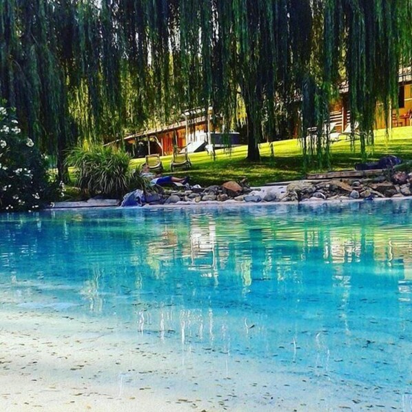 Una piscina al aire libre de temporada, tumbonas