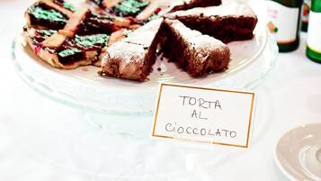 Une assiette de desserts comprenant une tarte et des brownies au chocolat, avec l’inscription « TORTA AL COCCOLATO ».