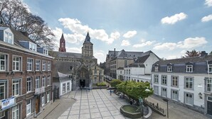 Una plaza histórica con adoquines, una fuente en el centro y edificios circundantes de arquitectura tradicional.