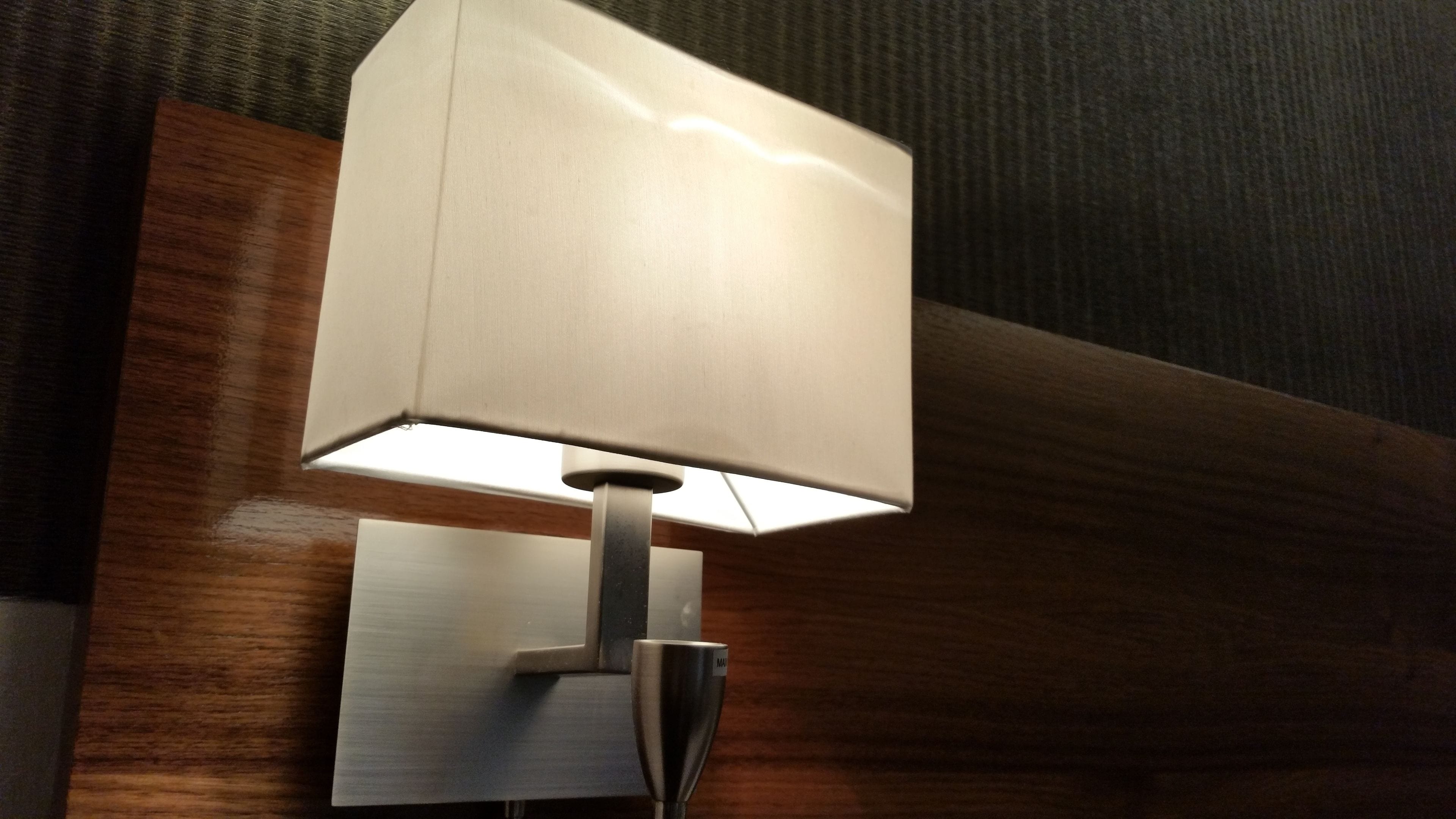 A wall-mounted lamp with a rectangular shade and a metallic base.