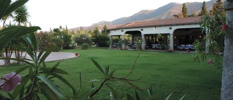 A covered outdoor seating area with a mountain backdrop.