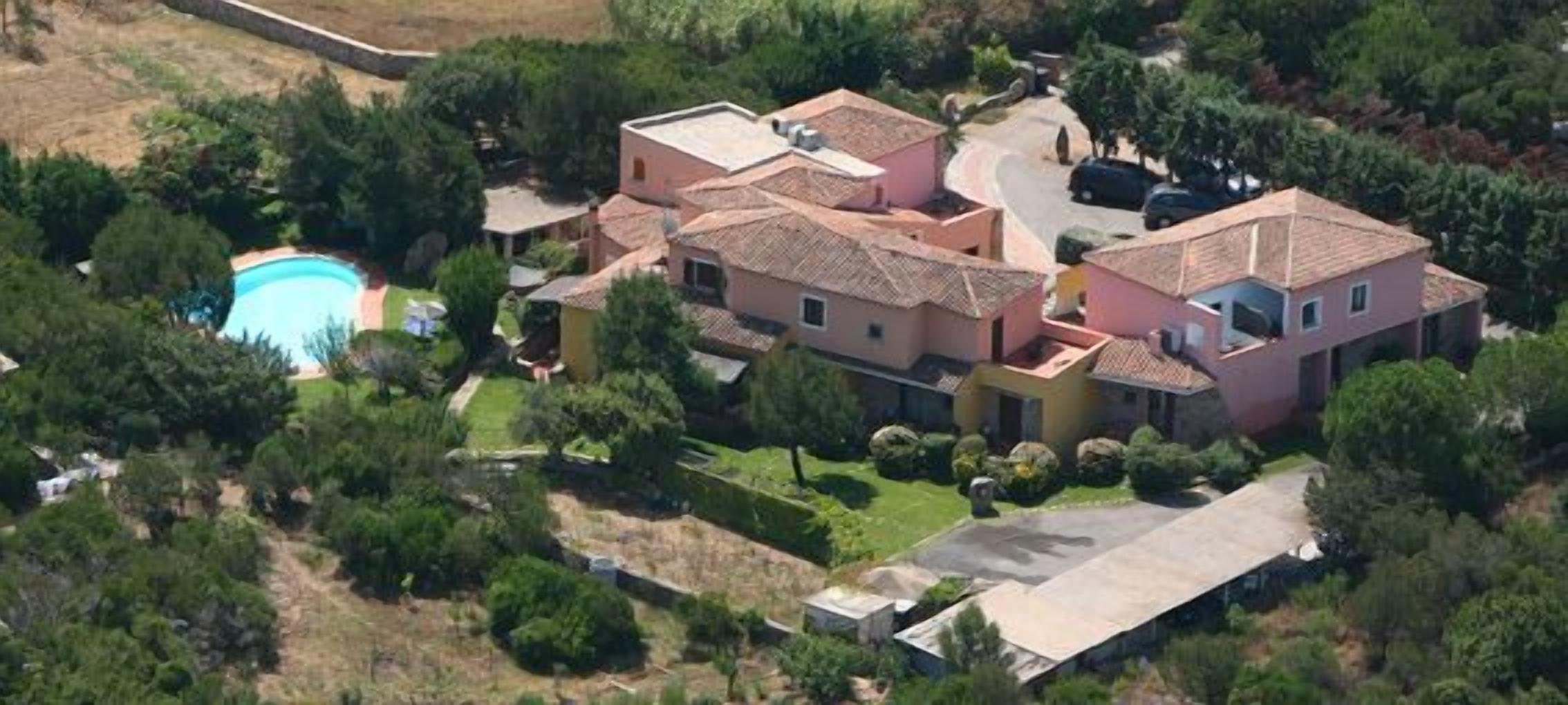Un barrio residencial con varias casas, una piscina y un jardín bien cuidado.