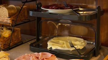 Un buffet con diversi cibi, tra cui pane, prosciutto e pomodori.