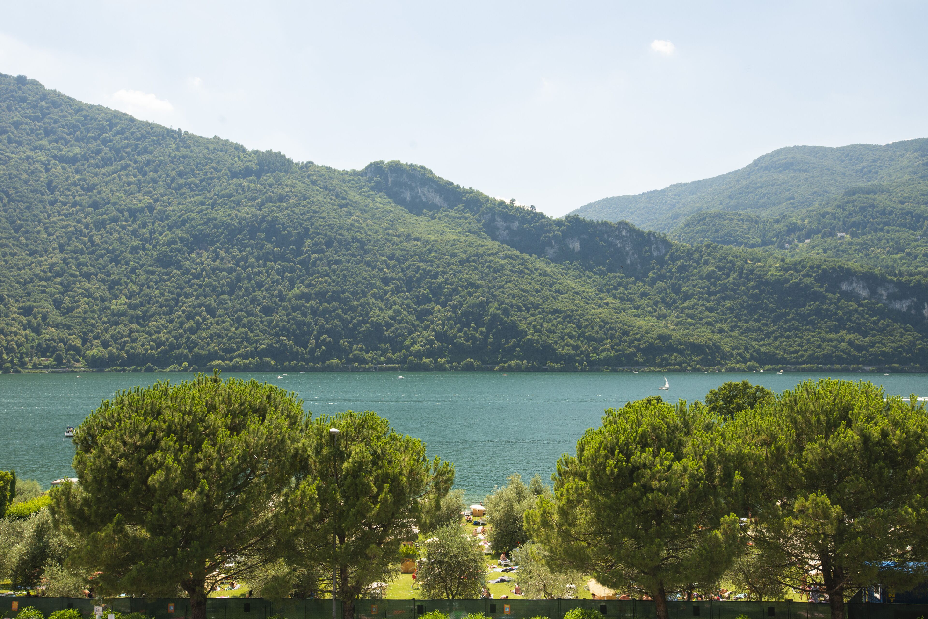 A lake surrounded by forested hills with a view of a boat on the water.
