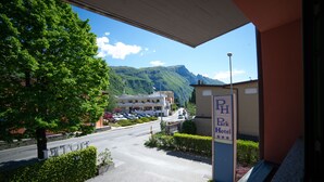 L’entrée d’un hôtel, avec une enseigne indiquant « Park Hotel », et une vue sur une route menant à un bâtiment où sont garées des voitures.