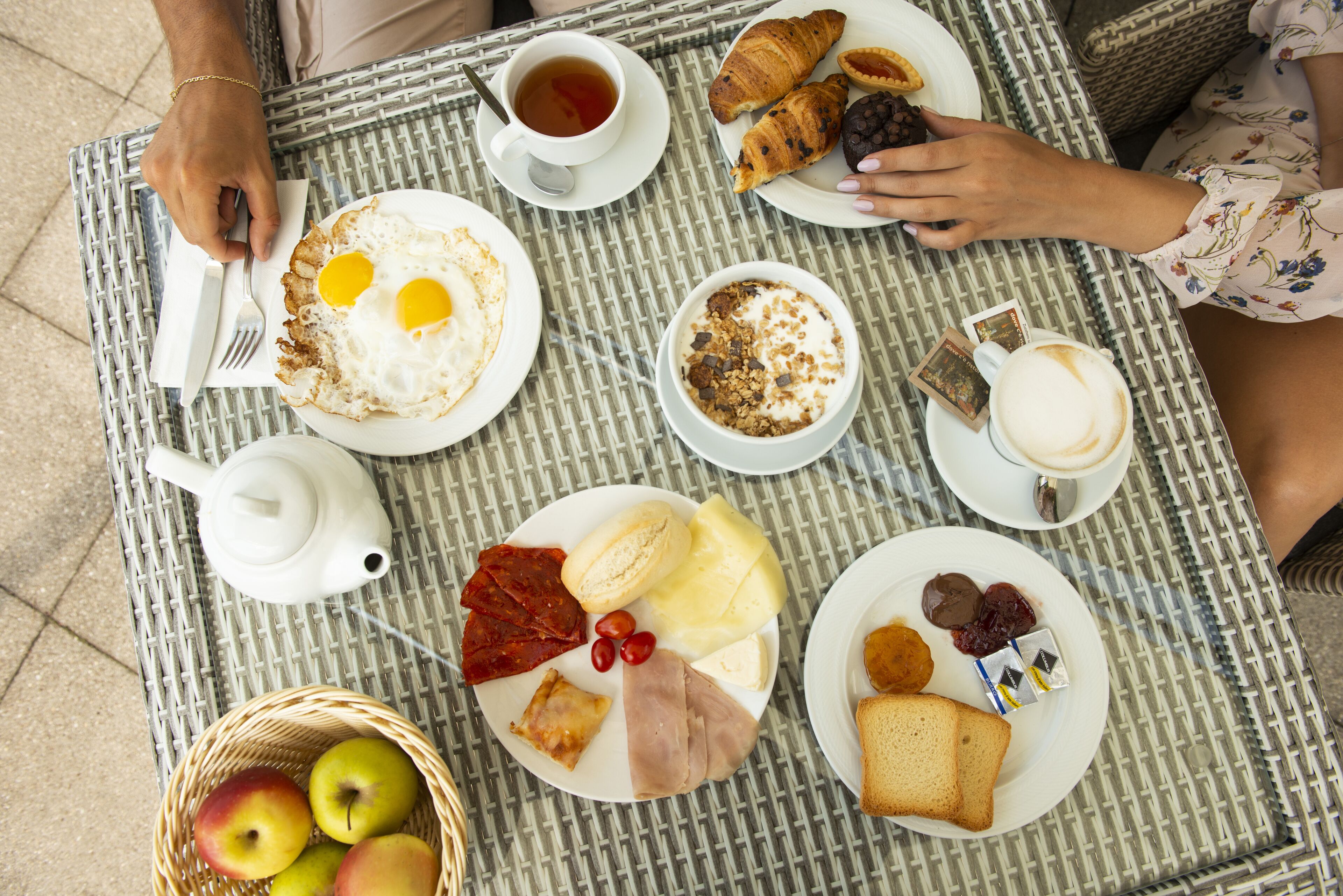 A table with breakfast items including eggs, croissants, and coffee.