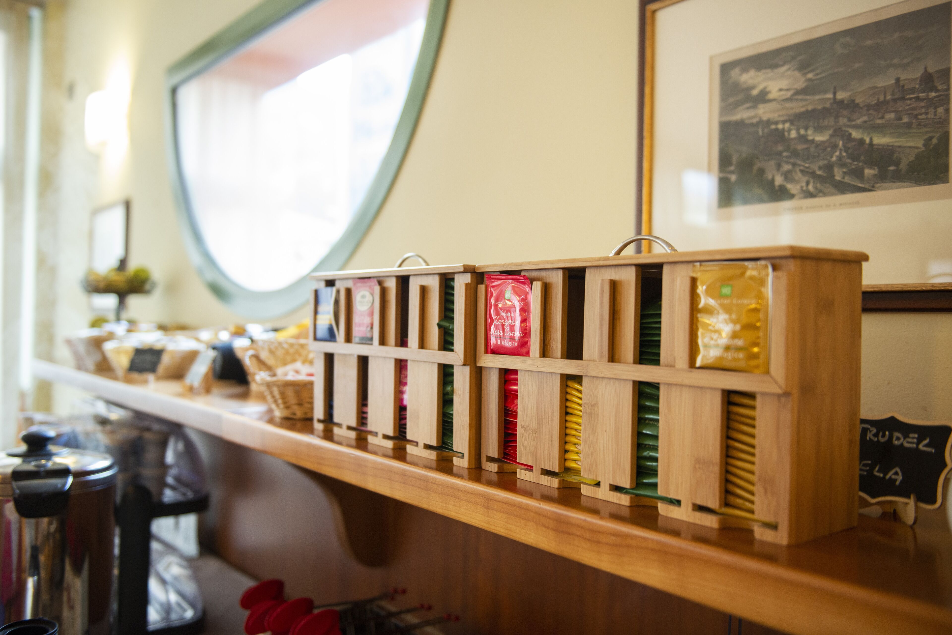 Una vitrina de madera con varios productos empaquetados, una cafetera y un cartel de pizarra.