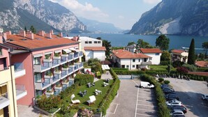 Un hôtel doté de nombreux balcons, d’un parking et offrant une vue sur un lac et des montagnes.
