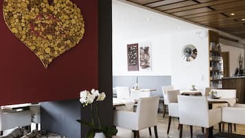 Un intérieur moderne agrémenté d’une décoration murale en forme de cœur, de meubles blancs et d’un plafond en bois.