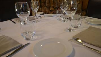Una mesa servida con copas de vino, platos y cubiertos.