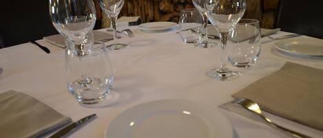 Une table mise avec des verres à vin, des assiettes et des couverts.