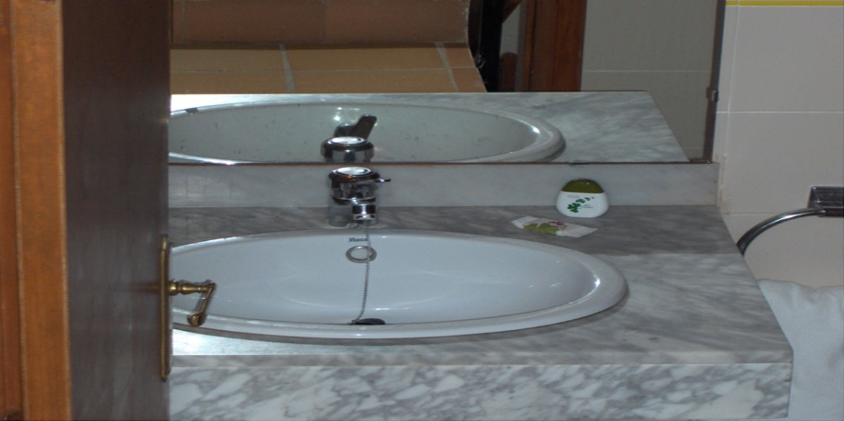 A bathroom with a sink, mirror, and a small decorative item on the countertop.