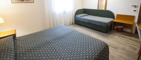 Una habitación de hotel con una cama grande, un sofá, una silla y una mesita.