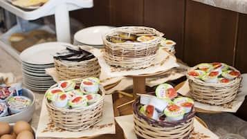 Une table de buffet proposant divers plats, notamment des paniers de yaourts et des œufs.