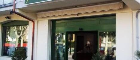 Het uiterlijk van Hotel Italia met een groen luifel, een bord en plantenbakken voor.