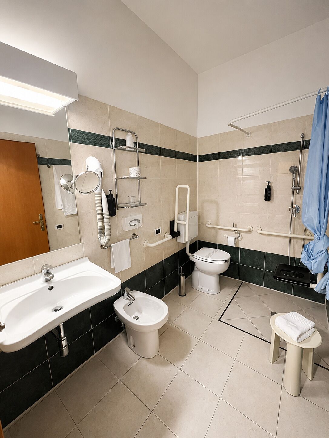 Un baño moderno con lavamanos, bidé, inodoro y ducha.