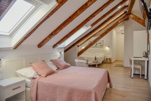 Cozy retreat with a sloped ceiling, featuring a bed, nightstand, and chair.