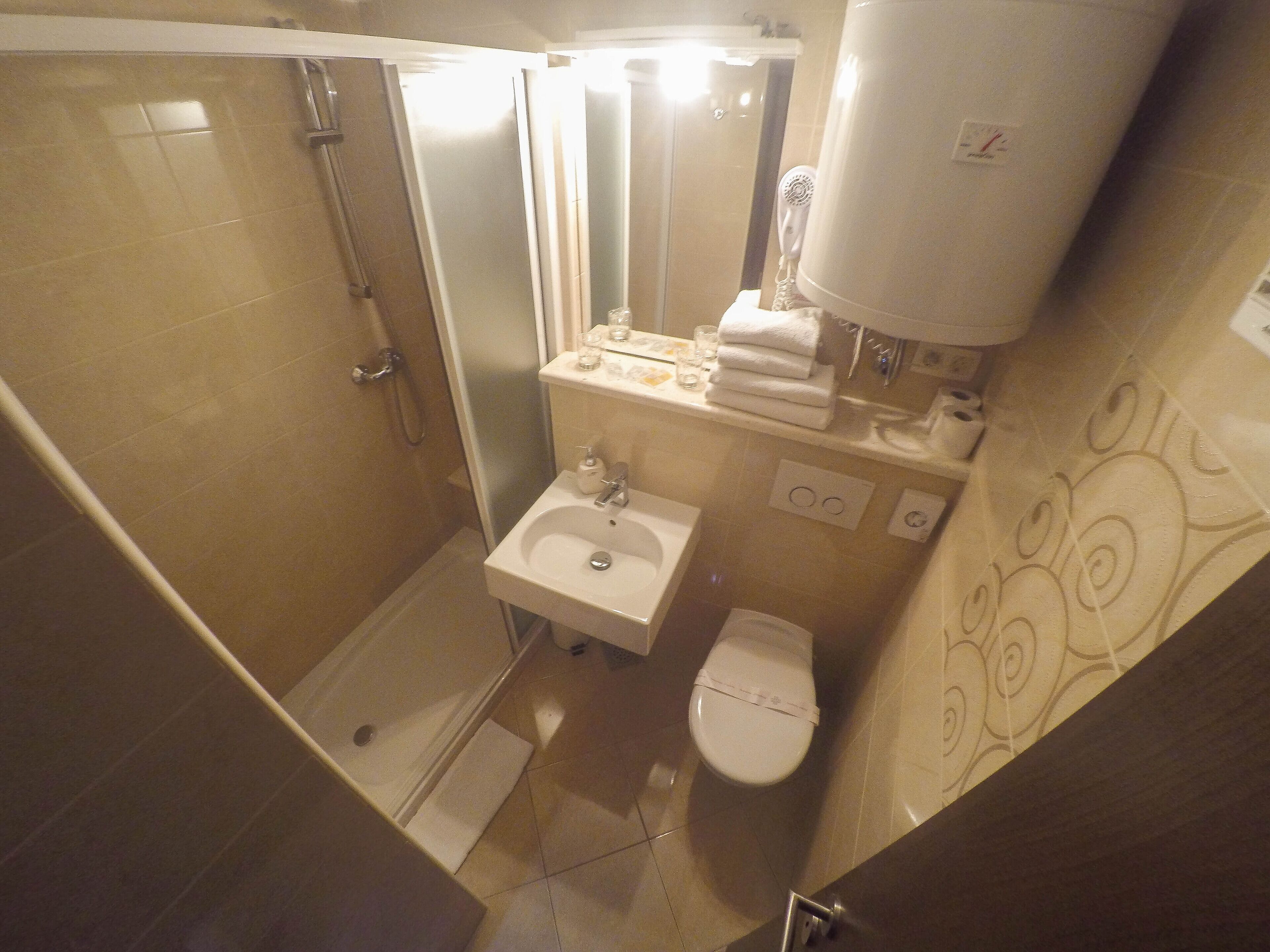 A compact bathroom with a shower, toilet, and sink.