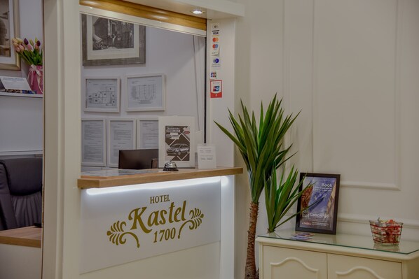 Una mesa de recepción de hotel con un cartel que dice "Hotel Kastel 1700".