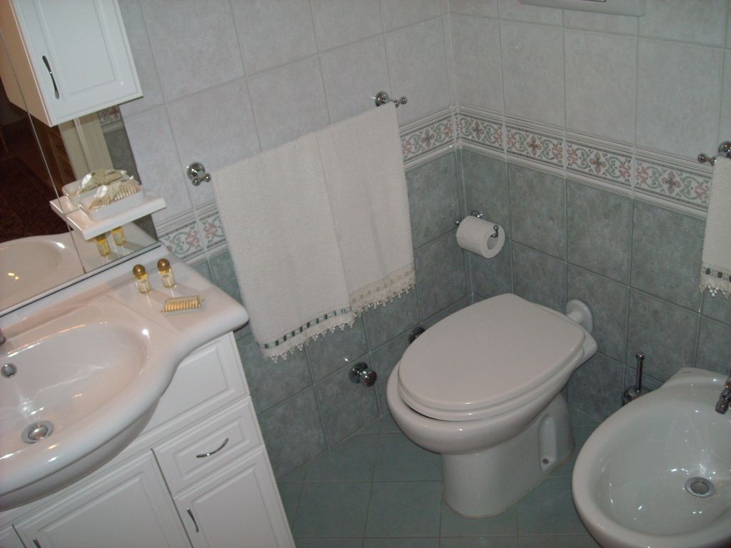 A bathroom with a sink, toilet, and bidet.