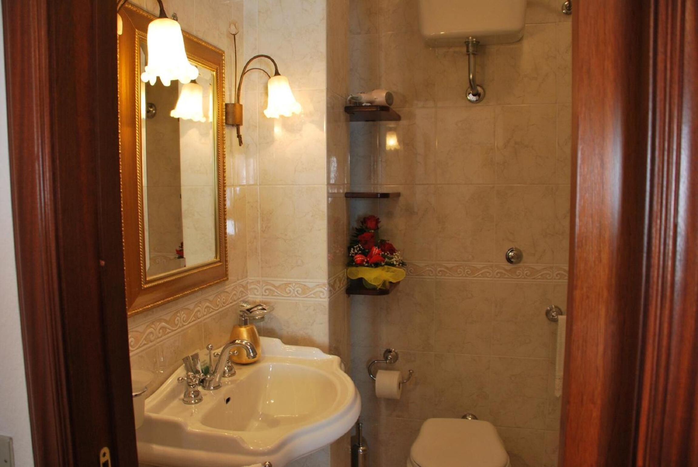 A bathroom with a sink, mirror, toilet, and shower.