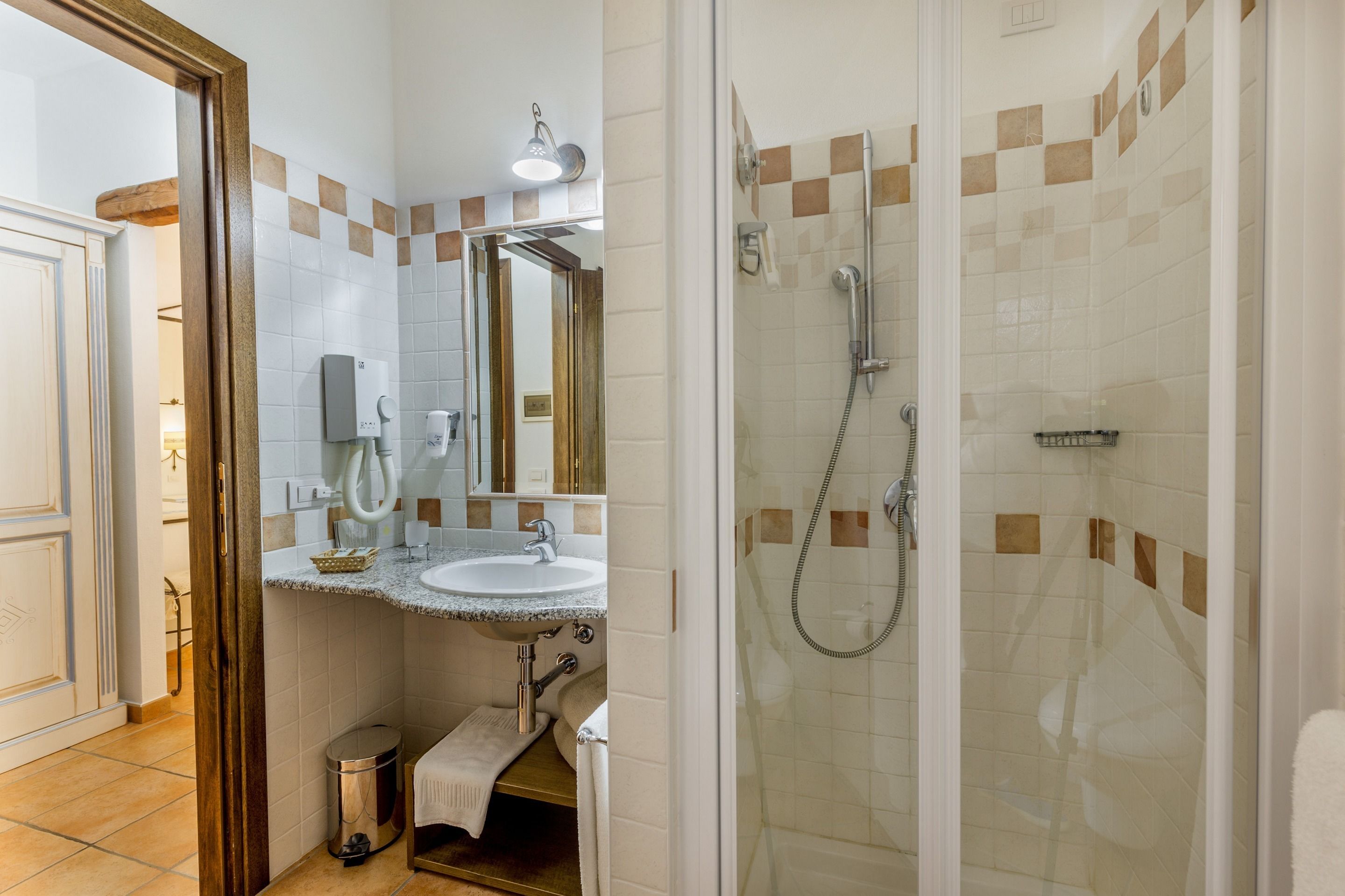 A bathroom with a sink, mirror, and shower.