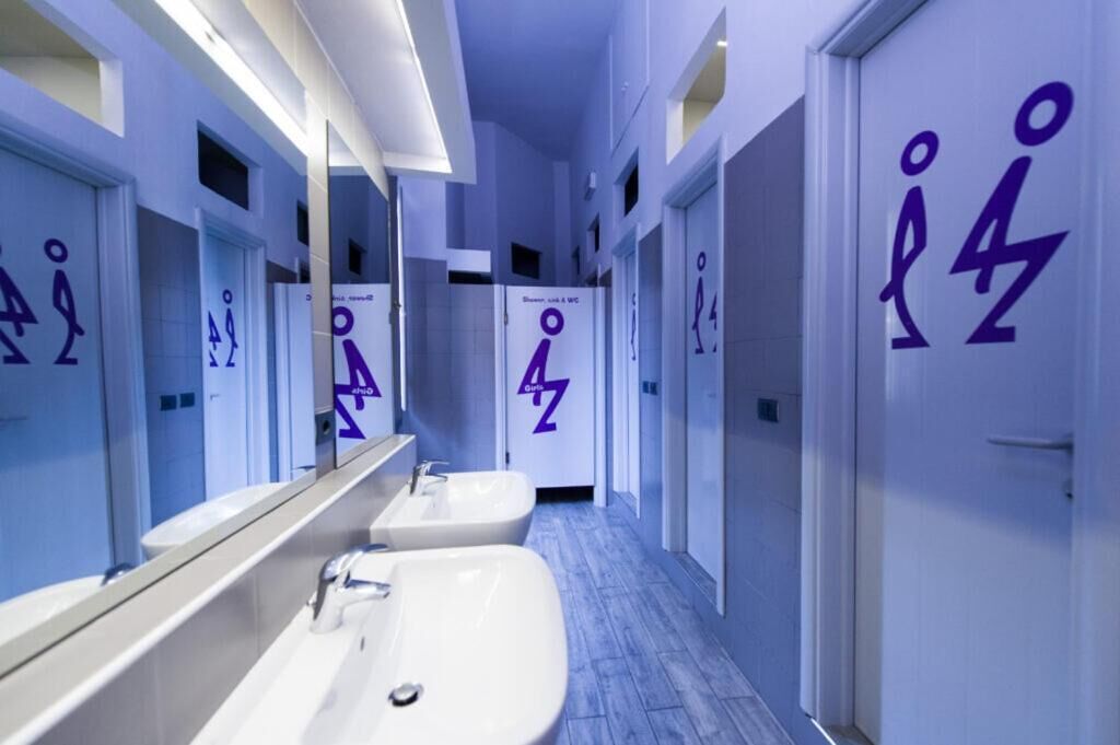 Un baño moderno con varios lavamanos y espejos, cada uno con un número único.