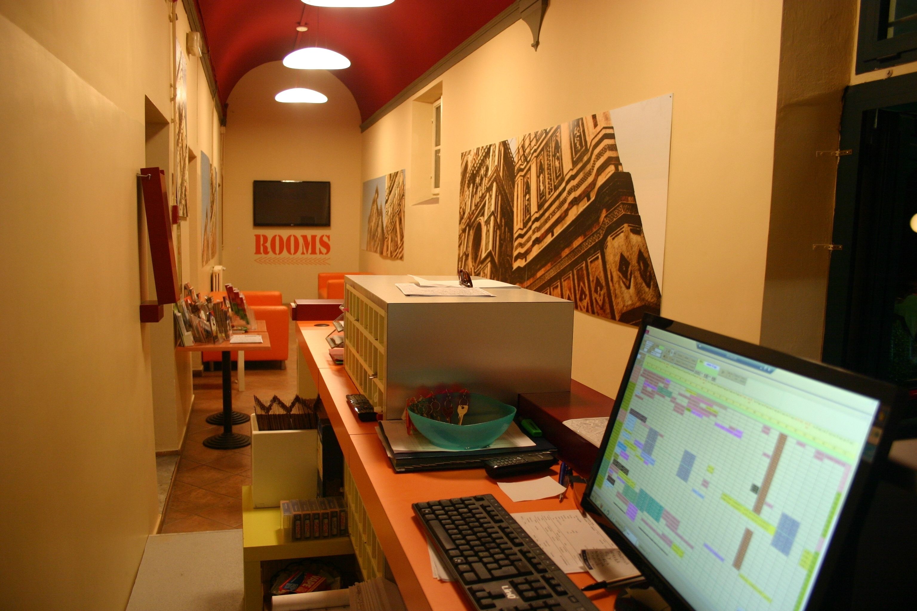 A room with a desk, computer, and a large window.