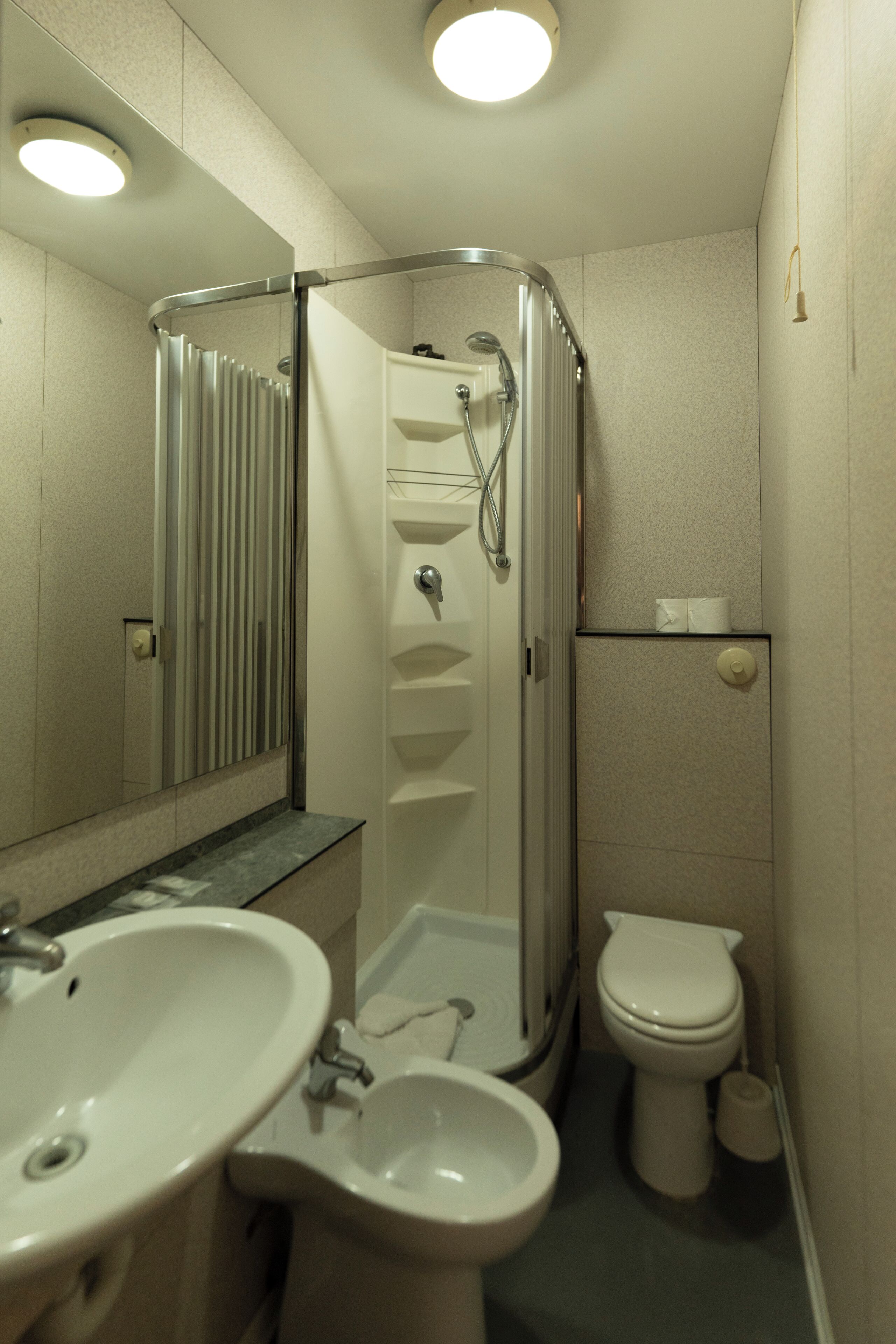 A bathroom with a shower, sink, and toilet.