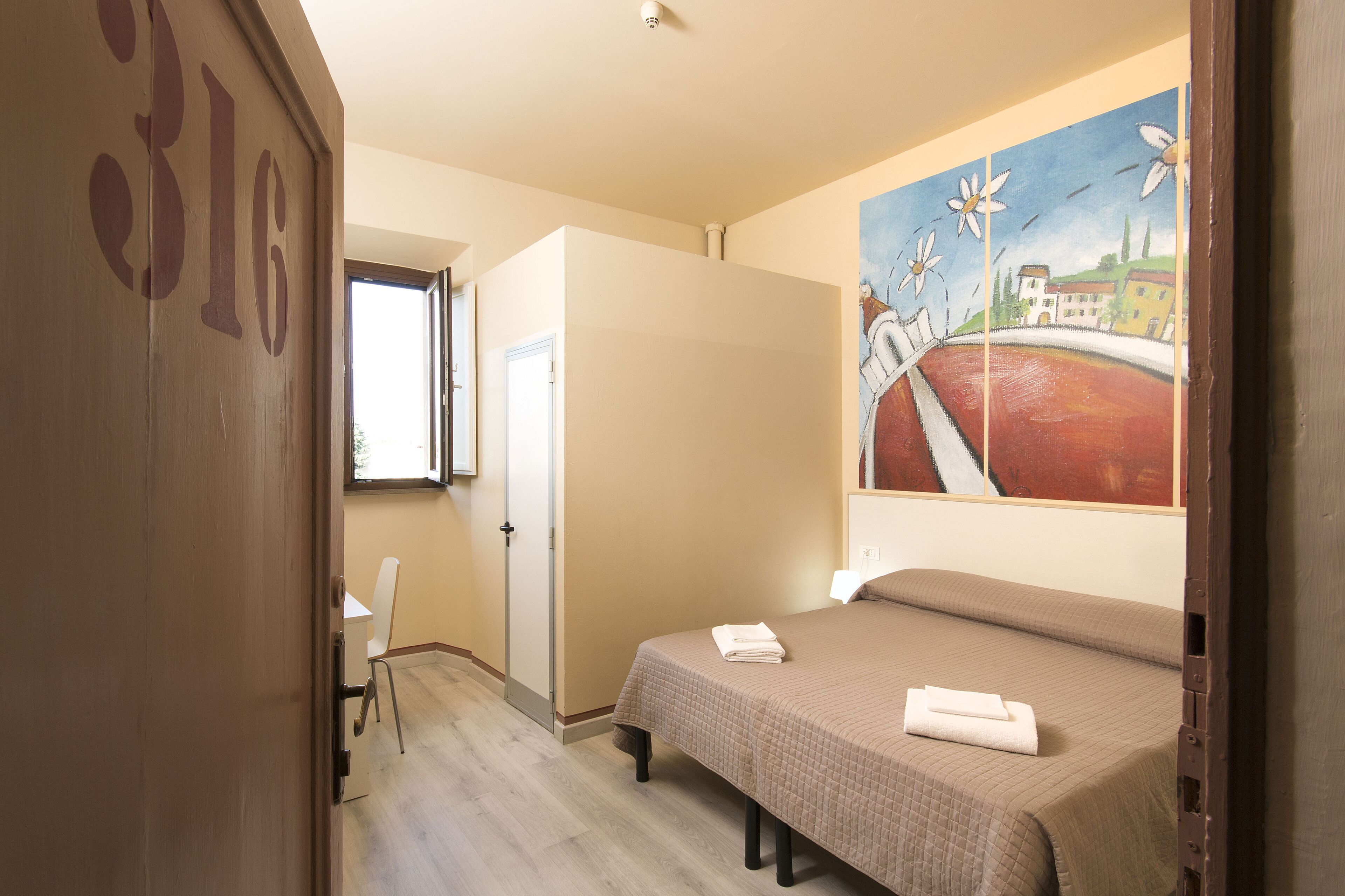 Ein Schlafzimmer mit einem Bett, einem Bild an der Wand und einer Tür mit der Nummer 316.