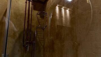 A shower with a glass enclosure, a sink, and a towel rack.